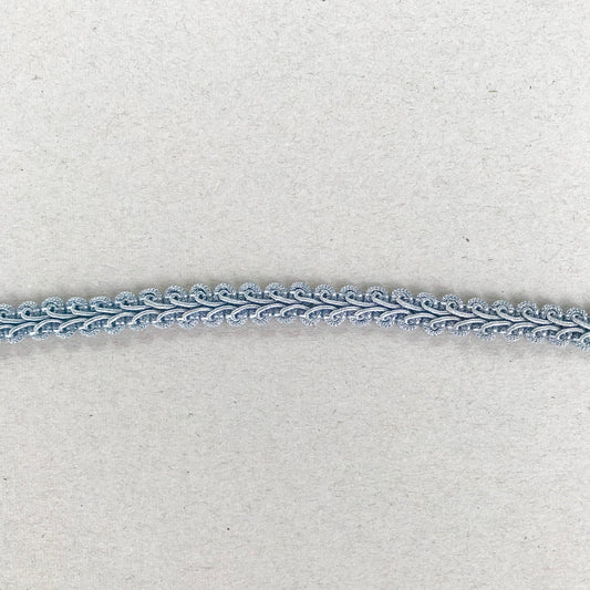 Dekorband Fairy Blue i ljus isblå med scrollmönster och små öglor, 1 cm brett