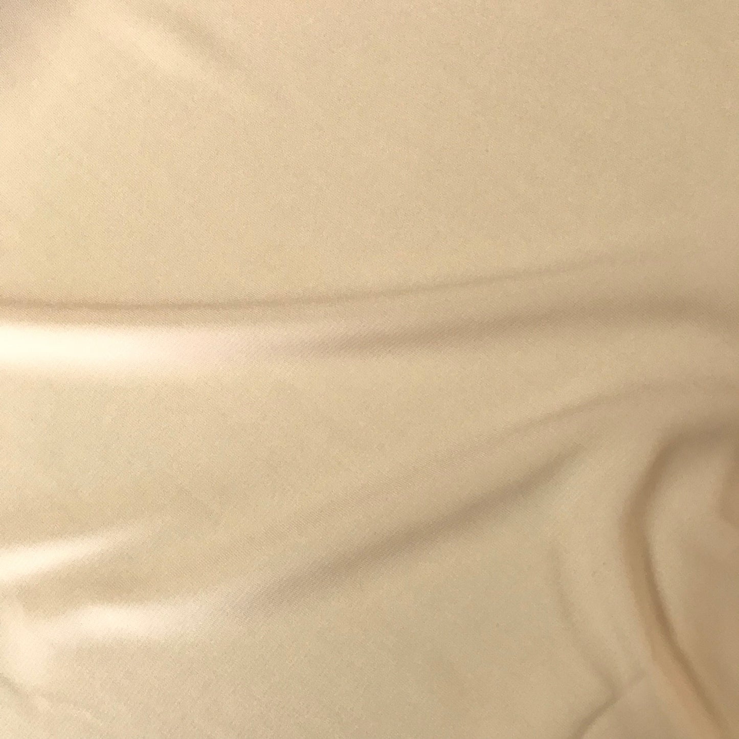Crepetyg ljusbeige visat som elegant blus med rynkad halsringning, mjukt flödande